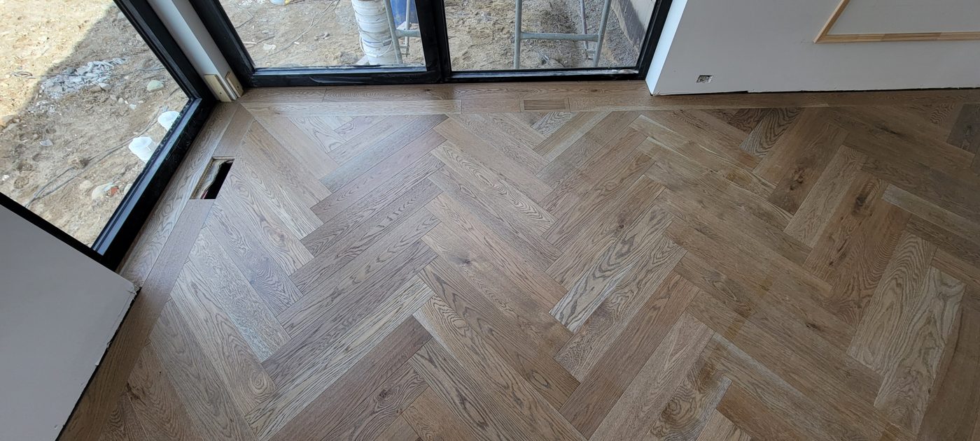 Plancher à chevrons en chêne blanchi, coin fenêtre, lumière naturelle Plancher à chevrons en chêne blanchi, coin fenêtre, lumière naturelle