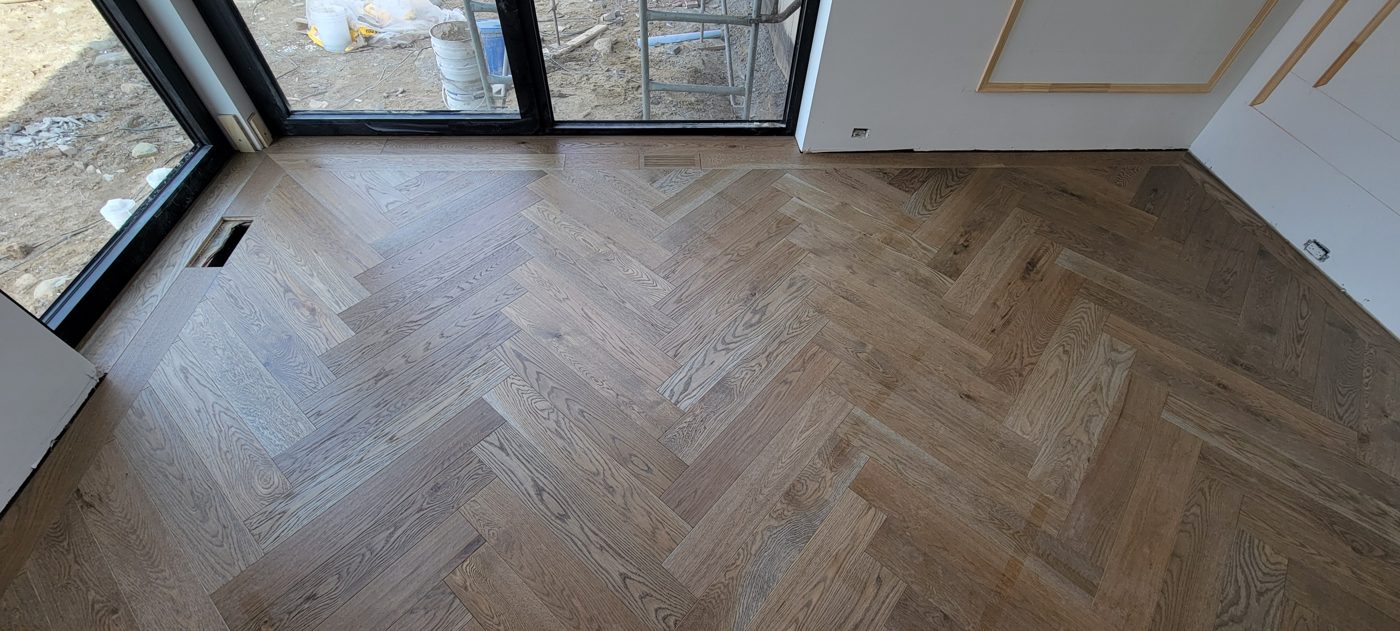 Plancher à chevrons en chêne blanchi avec grille de ventilation en bois intégrée