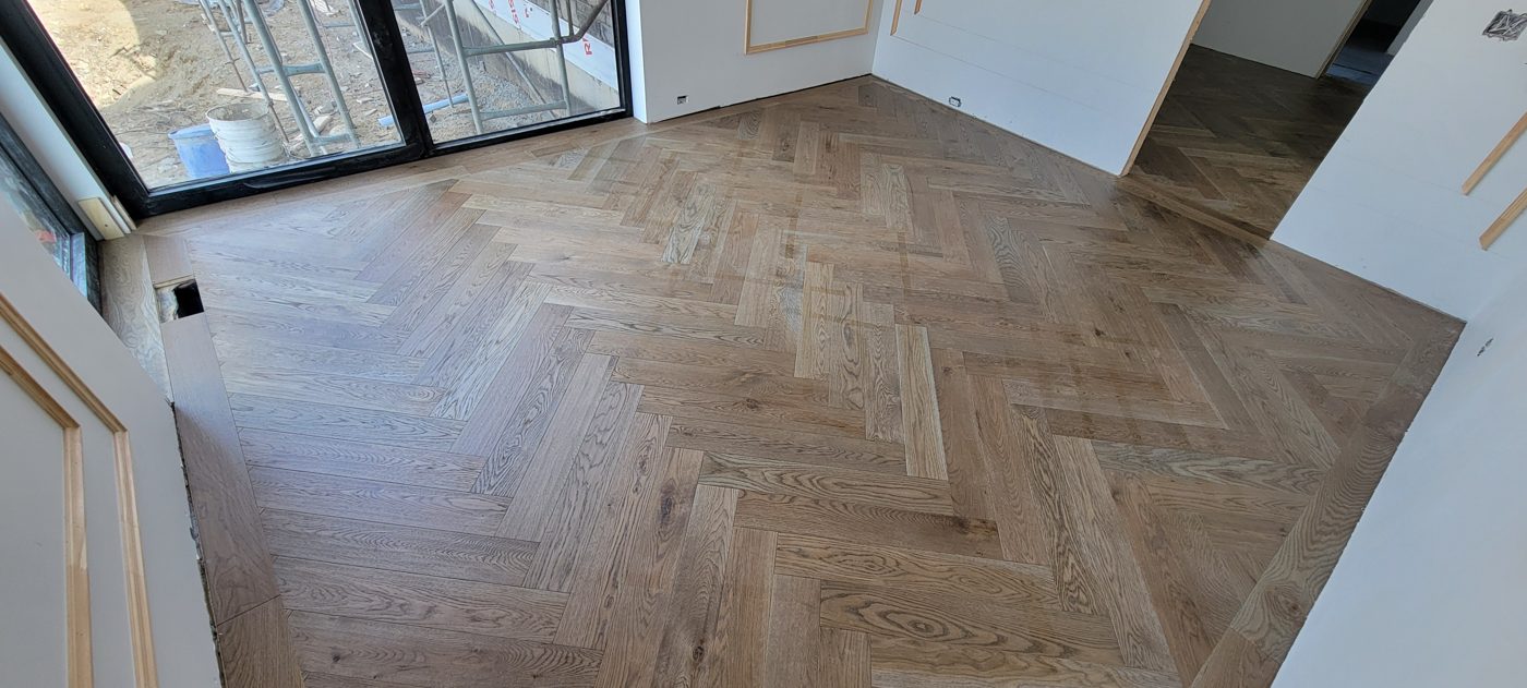 Plancher à chevrons en chêne blanchi, vue en angle de la pièce principale