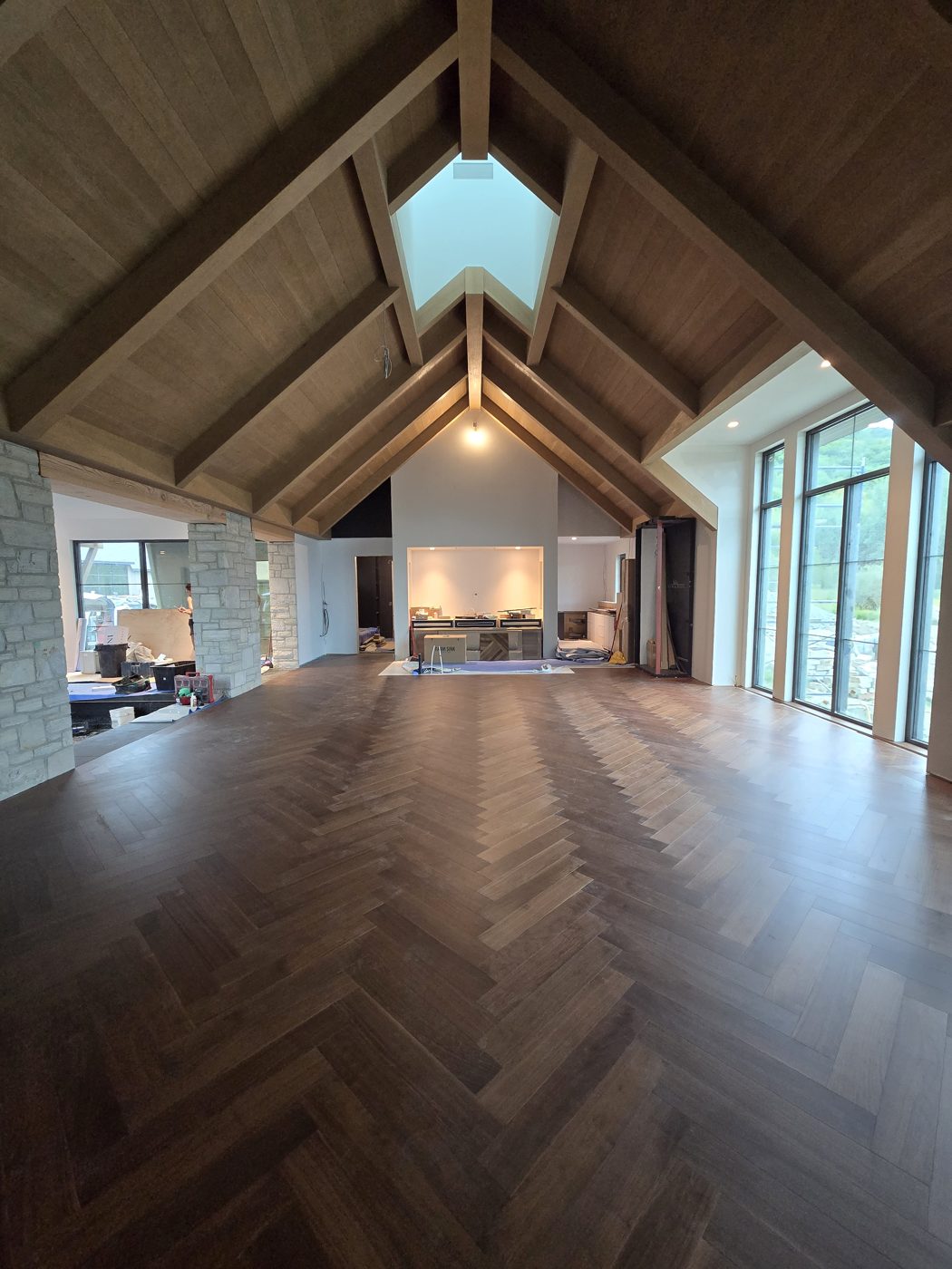 Plancher de noyer à chevrons sous un puits de lumière, chalet au Mont Owl’s Head Plancher de noyer à chevrons sous un puits de lumière, chalet au Mont Owl’s Head