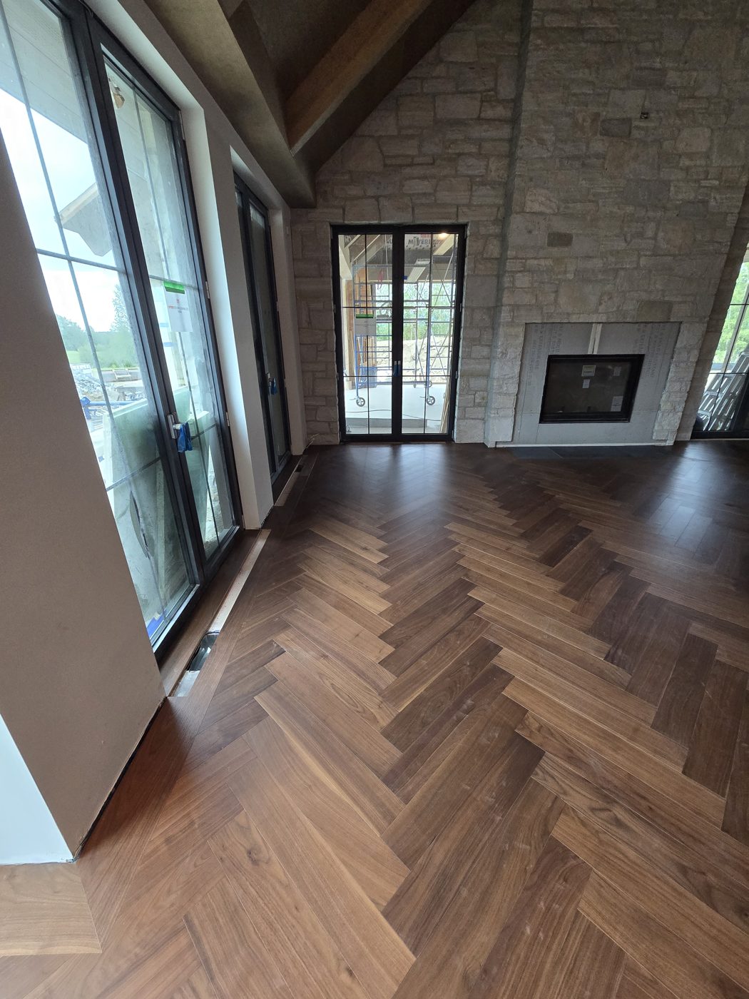 Plancher à chevrons en noyer menant au foyer de pierre et aux portes-fenêtres, Potton Plancher à chevrons en noyer menant au foyer de pierre et aux portes-fenêtres, Potton