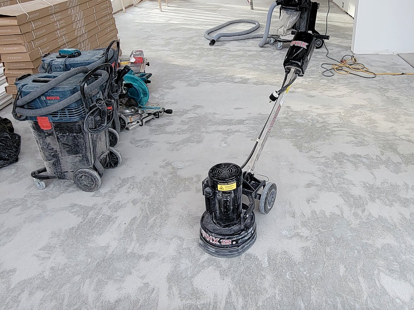 Meulage d’une dalle de béton en cours avec aspiration des poussières, Estrie