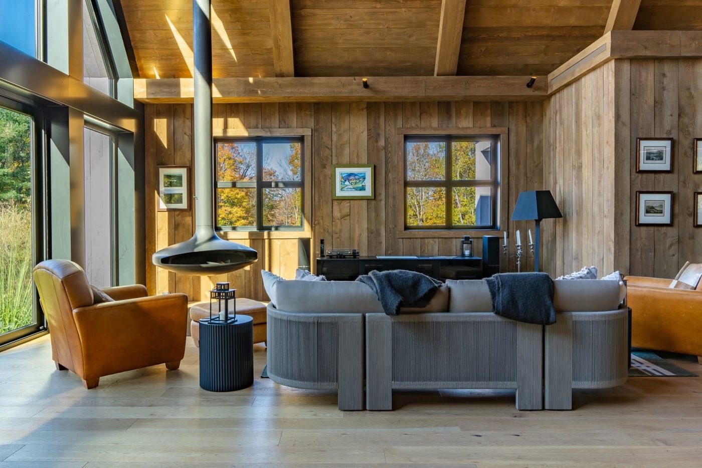 Salon de chalet rénové avec plancher de chêne clair et poutres de bois Salon de chalet rénové avec plancher de chêne clair et poutres de bois